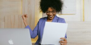 Frau hält ein Blatt Papier in der Hand. Karriere-Kick